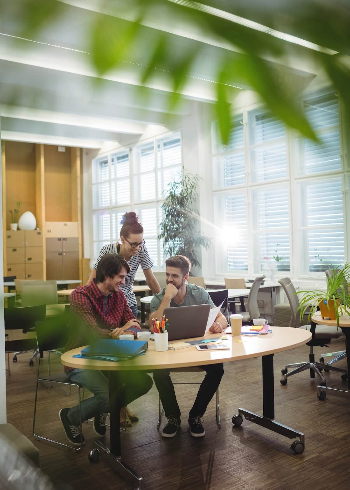 3 personnes dans un bureau qui collaborent